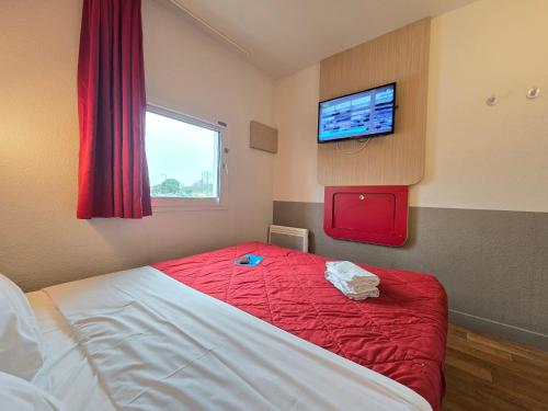 a bedroom with a bed and a tv on a wall at Premiere Classe Thionville - Yutz in Basse-Yutz
