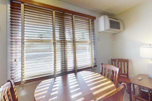 a dining room with a wooden table and a window at Unit 117 for Poolside Fun in Wells