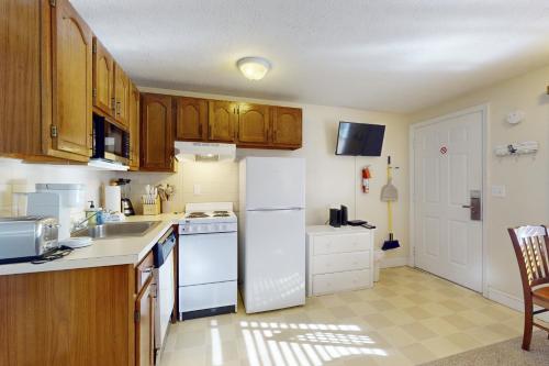 a kitchen with a white refrigerator and a sink at Unit 117 for Poolside Fun in Wells