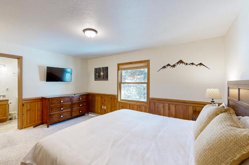 a bedroom with a bed and a tv on the wall at Snowfire 308A in Angel Fire