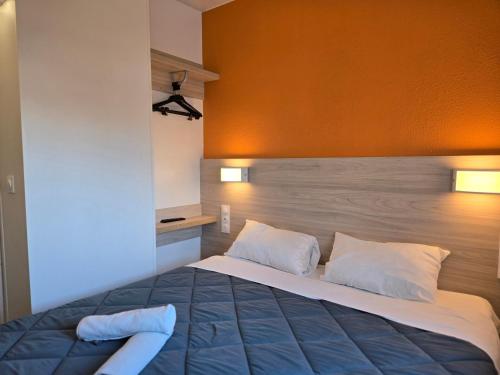a bedroom with a large bed with a wooden headboard at Premiere Classe Thionville - Yutz in Basse-Yutz