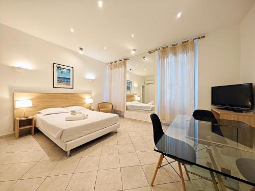 a bedroom with a bed and a table and a television at Viva Riviera 11 rue Commandant André in Cannes