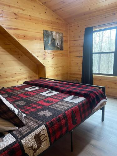 una camera con un letto in una baita di tronchi di The Quana - Hot tub, fire pit, and Huge Entertainment Area a Logan