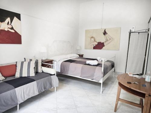 sypialnia z 2 łóżkami i stołem w obiekcie B&B La Corte w mieście SantʼAntimo