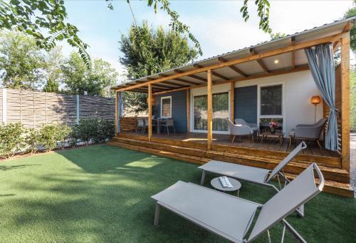 a backyard with a wooden deck with chairs and a table at Club del Sole Tenuta Primero Grado Family Collection in Grado