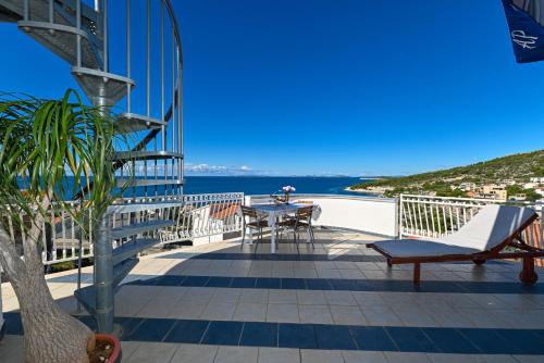 a balcony with a table and chairs and the ocean at Apartments Marić in Primošten