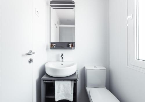 a white bathroom with a sink and a toilet at Club del Sole Tenuta Primero Grado Family Collection in Grado
