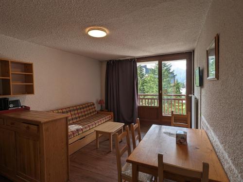 un salon avec un canapé et une table dans l'établissement Studio Pied de Piste au Centre + Animaux admis - FR-1-811-12, à Les Deux Alpes