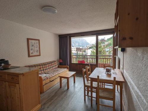 un salon avec un canapé et une table dans l'établissement Studio familial, au pied des pistes, animaux admis - FR-1-811-15, à Les Deux Alpes