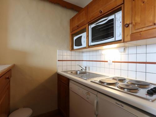 une cuisine avec une cuisinière, un évier et un micro-ondes dans l'établissement Studio familial animaux admis - 4 pers, au cœur des Deux Alpes - FR-1-811-2, à Les Deux Alpes
