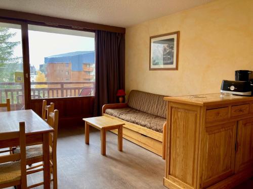 un salon avec un canapé et une table dans l'établissement Studio lumineux aux Deux Alpes - Animaux admis - FR-1-811-17, à Les Deux Alpes