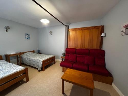 - une chambre avec un canapé rouge et un lit dans l'établissement T2 central à La Roche-Posay, 4 pers, WIFI, proche des Thermes - FR-1-541-160, à La Roche-Posay