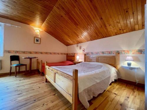 una camera da letto con un letto grande e un soffitto in legno di Chambre Saumon: Confort pour 4, Animaux Bienvenus - FR-1-582-487 ad Alleyras