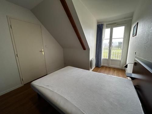 une chambre avec un lit et une grande fenêtre dans l'établissement T2 rénové avec piscine chauffée proche Thermes, parking et WIFI - FR-1-541-164, à La Roche-Posay