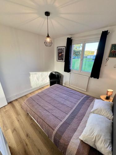 a bedroom with a large bed and a window at Le Cocooning in Aureilhan