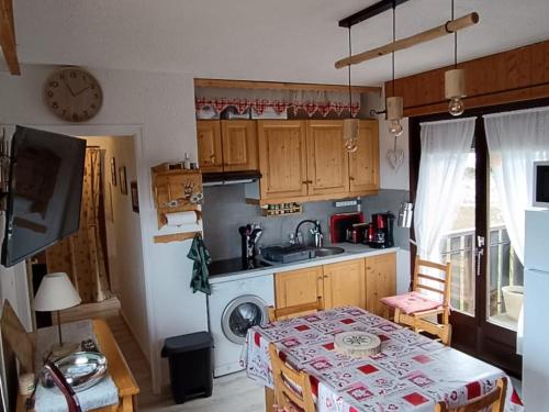une petite cuisine avec une table et un évier dans l'établissement Appartement cosy proche pistes ski avec garage - FR-1-498-112, à Thollon-les-Mémises
