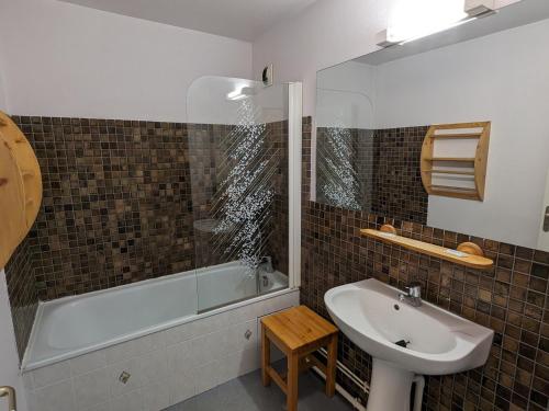 La salle de bains est pourvue d'un lavabo, d'une douche, d'une baignoire et d'un lavabo blanc. dans l'établissement Studio familial, animaux admis, au pied des pistes - FR-1-811-16, à Les Deux Alpes