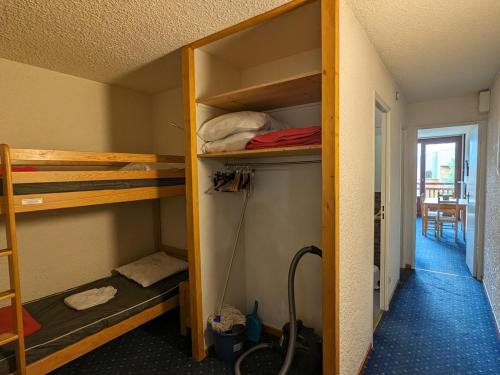 Cette chambre dispose de lits superposés et d'un couloir avec une table. dans l'établissement Studio familial, animaux admis, au pied des pistes - FR-1-811-16, à Les Deux Alpes