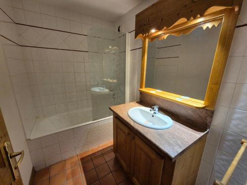 une salle de bain avec un lavabo, un miroir et une baignoire dans l'établissement Studio lumineux, pied des pistes, animaux admis - FR-1-811-27, à Les Deux Alpes