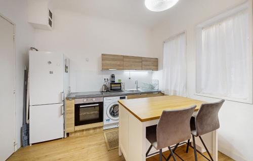 Il comprend une cuisine équipée d'un réfrigérateur blanc et d'une table avec des chaises. dans l'établissement 1 Bedroom Stunning Apartment In Royan, à Royan