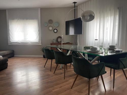 a dining room with a glass table and chairs at Casa da Villa in Vila Nova de Foz Coa