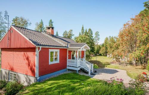 a red house with a white porch and a yard at Beautiful Home In Ockelbo With Wifi in Ockelbo