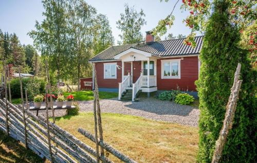 a red house with a fence and a yard at Beautiful Home In Ockelbo With Wifi in Ockelbo