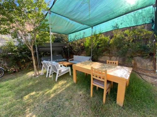 a table and chairs under a tent in a yard at Hermon Garden Apartment in Majdal Shams
