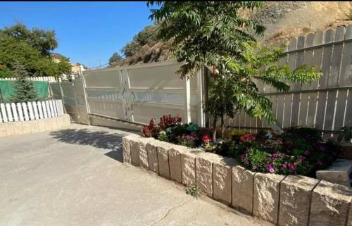 a fence with a bunch of flowers in a garden at Hermon Garden Apartment in Majdal Shams