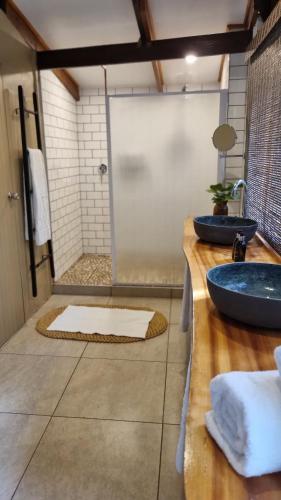 a bathroom with two sinks and a shower at Honeywood Forest Lodge in Port Shepstone