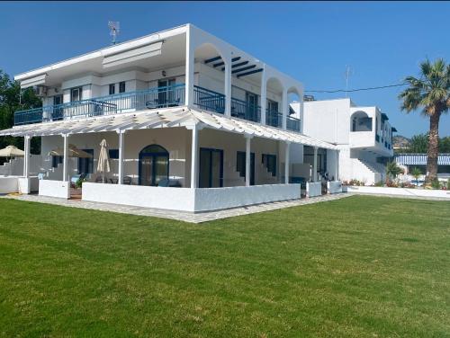 a white house with a lawn in front of it at Ariadni Blue 2 in Neos Marmaras