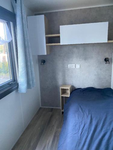 a small bedroom with a bed and a window at MH 3CH à l'océan Landais chez Claiclé in Saint-Julien-en-Born