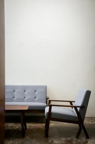 a couch and a chair in a room at Aayu Pantai - George Town, Penang in George Town