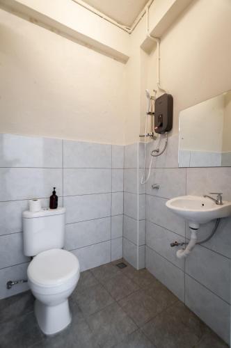 a bathroom with a toilet and a sink at Aayu Pantai - George Town, Penang in George Town