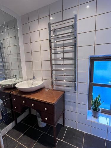 a bathroom with a sink and a mirror and a window at Claires Cottage in Bethesda