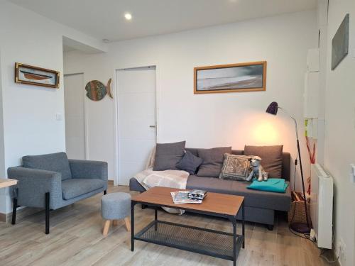 un salon avec un canapé et une table dans l'établissement Maison St Marc proche plage, 3chambres, à Saint-Nazaire