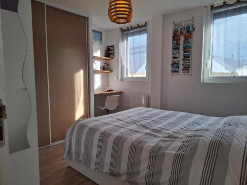 une chambre avec un grand lit et une fenêtre dans l'établissement Maison St Marc proche plage, 3chambres, à Saint-Nazaire