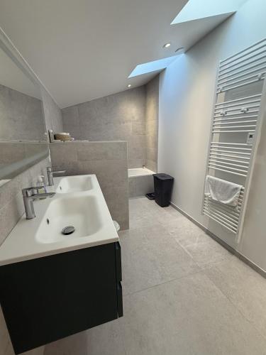 une salle de bain avec un lavabo et une baignoire dans l'établissement Villa d'exception à Lacanau océan, à Lacanau
