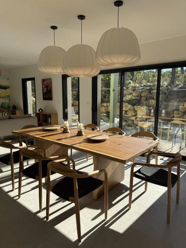 une salle à manger avec une table et des chaises en bois dans l'établissement Villa d'exception à Lacanau océan, à Lacanau