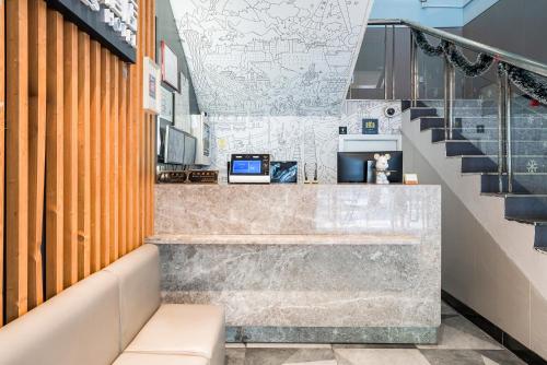 a lobby of a building with stairs and a counter at Meego Yes Hotel in Shanghai