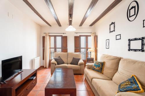 a living room with a couch and a tv at Cueva Del Gollisno in Chulilla