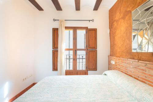 a bedroom with a bed and a window at Cueva Del Gollisno in Chulilla