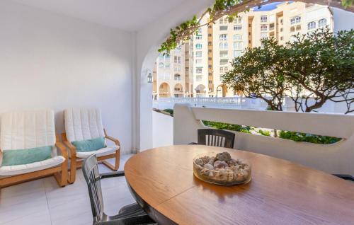 ein Esszimmer mit einem Tisch und Stühlen sowie ein Gebäude in der Unterkunft Beautiful Apartment In San Javier in San Javier