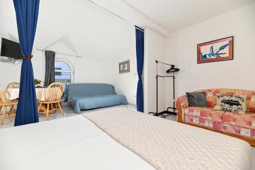 a bedroom with a bed and a couch and a table at Apartments Marić in Primošten