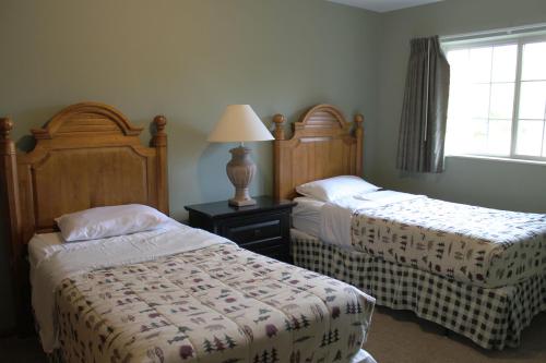 a bedroom with two beds and a lamp and a window at 2 Bedroom Condo Duck Lake in Eagle River