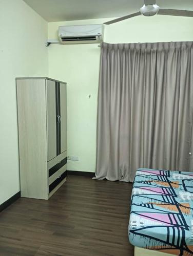 a room with a bed and a tv and a curtain at IJM Sri Utama Condo in Sandakan