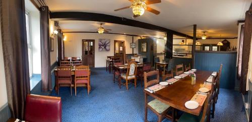 a dining room with wooden tables and chairs at Leaking Well, Dunhampton in Stourport