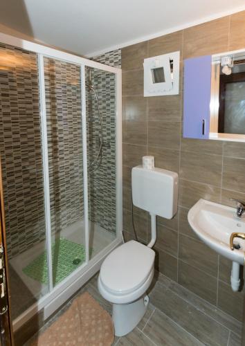 a bathroom with a toilet and a shower and a sink at Camping Roma in Ventimiglia