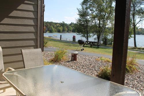 a grill sitting on a patio next to a lake at 2 Bedroom Lower Duck Lake Condo in Eagle River