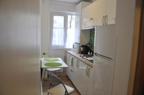 uma cozinha com uma pequena mesa e um frigorífico branco em SMP Apartment em Timişoara